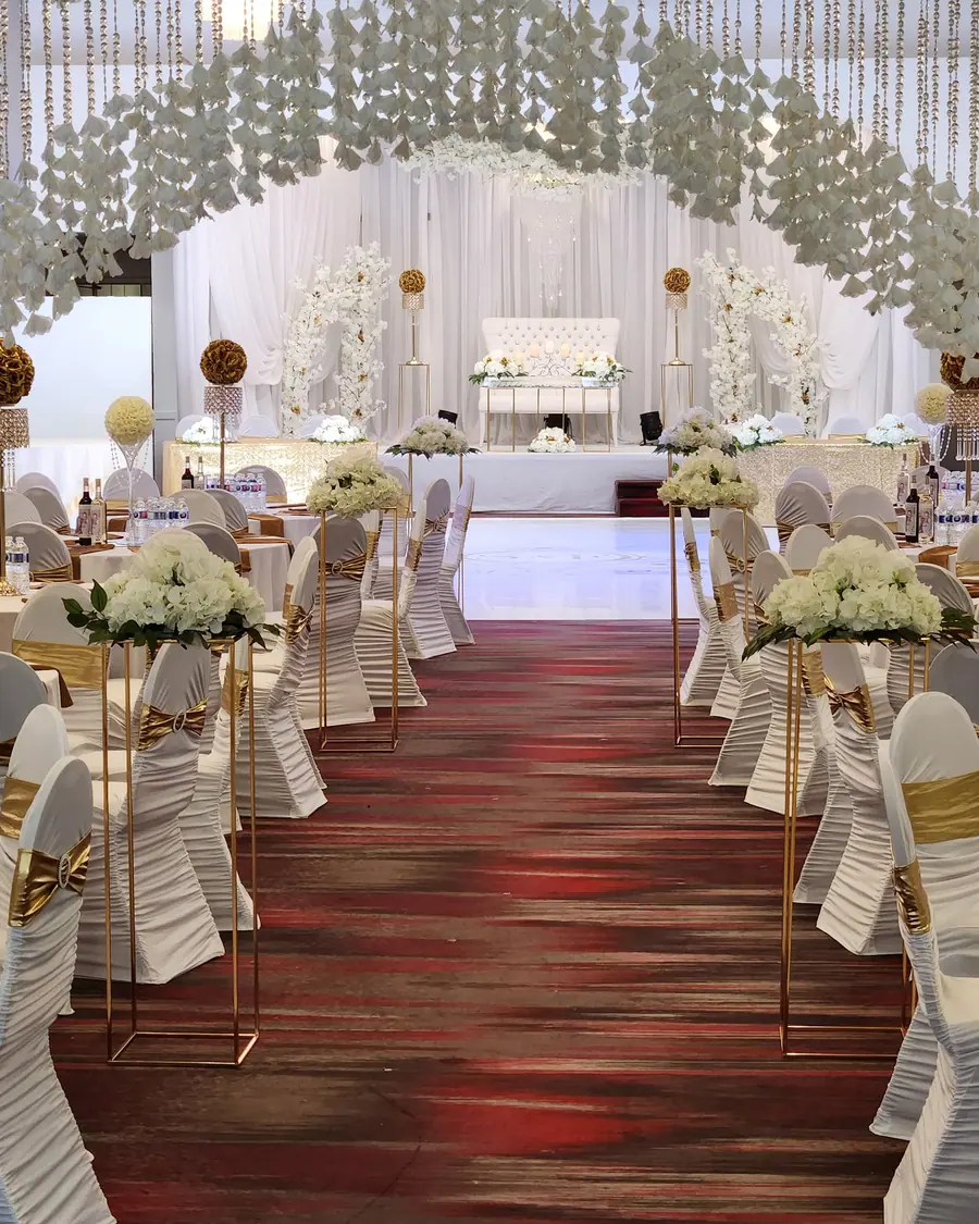 Wide Ottawa banquet hall dressed with beaded crystal ceiling drapes, white chair covers and gold sashes on every seat